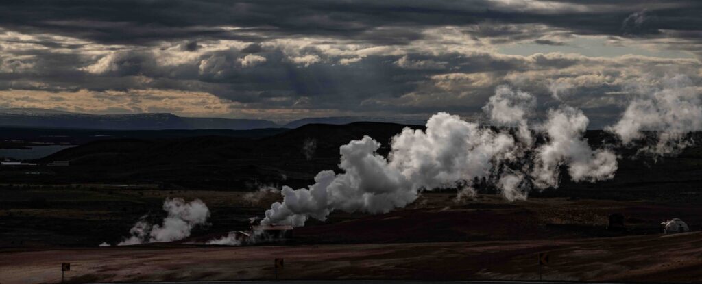 a group of smoke stacks rising out of the ground